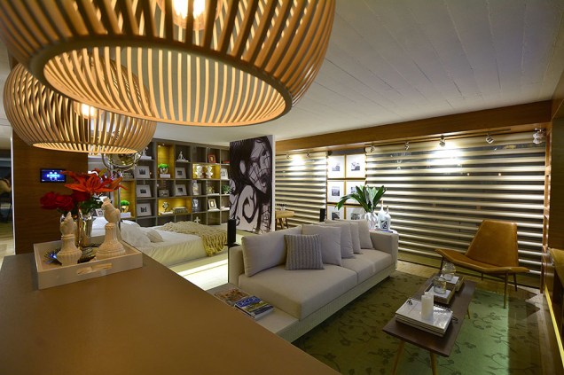 CASACOR Rio Grande do Sul 2015. Home Studio - Lisiane Wendel Corrêa e Simone Bertuzzo. Em 44 m², a dupla integrou living, cozinha, dormitório com escritório, banheiro e closet. A solução foi abusar da marcenaria sob medida, que também produziu peças exclusivas como a cama sobre tablado retroiluminado. No piso, a paginação em porcelanato rústico unifica os ambientes, aquecidos pelos painéis em madeira na mesma tonalidade. Nas poucas paredes, foi aplicado um papel com aparência de concreto. CASACOR Rio Grande do Sul 2015. Home Studio - Lisiane Wendel Corrêa e Simone Bertuzzo. Em 44 m², a dupla integrou living, cozinha, dormitório com escritório, banheiro e closet. A solução foi abusar da marcenaria sob medida, que também produziu peças exclusivas como a cama sobre tablado retroiluminado. No piso, a paginação em porcelanato rústico unifica os ambientes, aquecidos pelos painéis em madeira na mesma tonalidade. Nas poucas paredes, foi aplicado um papel com aparência de concreto.