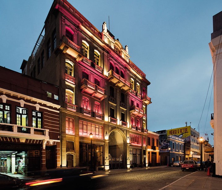 Iluminação da Fachada do Edifício Ronald - Veronica Saenz. Seu design de iluminação prima pelo tratamento da luz branca e das cores, de modo a destacar os elementos arquitetônicos principais deste edifício e conservar seu caráter patrimonial. Uma outra camada de luz permite criar cenas que relacionam o tradicional e o contemporâneo, utilizando tecnologia LED de última geração.