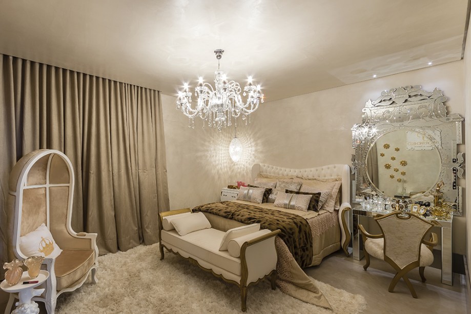 CASACOR Campinas 2016. Suíte da Filha - Junior Pacheco. A decoração clássica foi projetada com diferentes texturas de branco e o dourado, com detalhes que conferem glamour ao ambiente. O destaque é o espelho bisotado da penteadeira, igualmente espelhada.