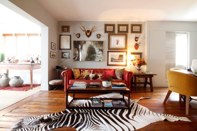 Nas paredes, quadros e esculturas de animais, conferem a esta sala um clima de chalé inglês. Ao centro, o sofá Chesterfield empresta cor ao lugar. Nas paredes, quadros e esculturas de animais, conferem a esta sala um clima de chalé inglês. Ao centro, o sofá Chesterfield empresta cor ao lugar.