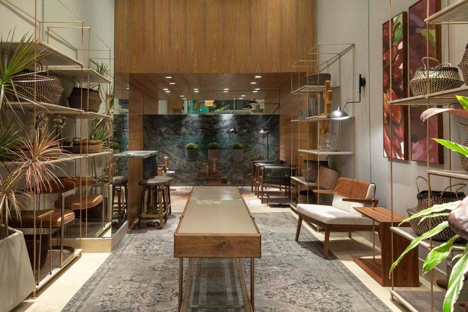 Loja CASACOR – Alessandra Nahas e Patrícia Nahas. Em 57 m², a dupla alia o conceito de flagship store, que aproxima a marca do cliente, ao de urban jungle, valorizando a natureza em grandes espécies de plantas. Para equilibrar, linhas retas e a madeira certificada conduzem o projeto, além de pinceladas de verde e dourado, para um resultado leve e contemporâneo.