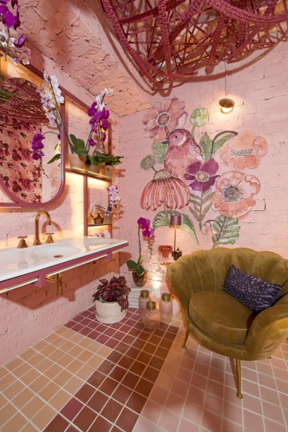 Lavabo Térreo - Anellise Bluhm, Carol Timbó e Mirna Albuquerque. O ponto de partida das profissionais da Utte Arquitetura foi a cor rosa, uma tendência na moda e na decoração, apostando na proposta de usar materiais e soluções de baixo custo. O piso, com paginação geométrica e exploração de cores, traz um efeito visual interessante, com revestimento cerâmico liso. Nas paredes, o tijolo artesanal pintado de rosa, confere charme e rusticidade. Uma pintura feita pela artista e ilustradora Auxi é um dos destaques.