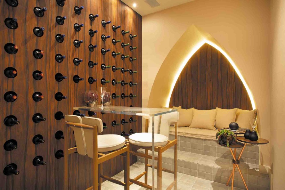 Sala do Vinho - Carol Azevedo e José Roberto Gouveia. Pensado como um espaço de múltiplas funções, o ambiente contempla da guarda de vinho à degustação. Com materiais cuidadosamente selecionados, a sala propõe funcionalidade e aconchego, além de experiência sensorial agradável, com contrastantes de cores, texturas e formas.