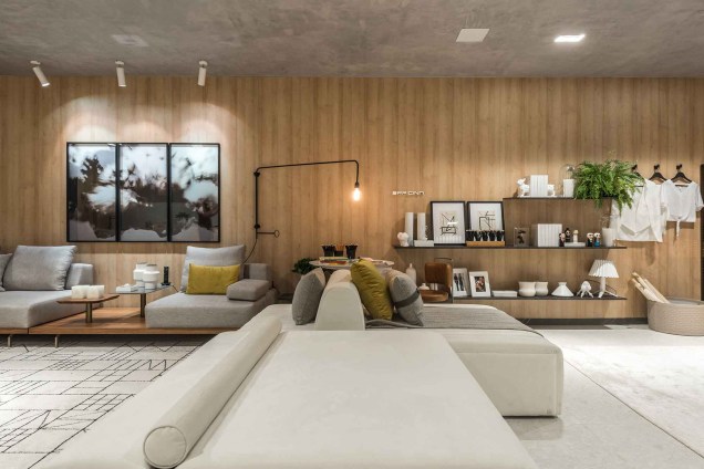 O amadeirado aparece no loft como a textura favorita, aparecendo como revestimento da maior parede do ambiente. Um grande sofá modular divide o quarto com a prateleira suspensa, que confere geometria à decoração. O amadeirado aparece no loft como a textura favorita, aparecendo como revestimento da maior parede do ambiente. Um grande sofá modular divide o quarto com a prateleira suspensa, que confere geometria à decoração.