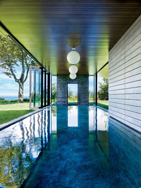 Piscinas no interior tendem a ter uma má reputação, mas este exemplo acaba com esse paradigma. Localizada na casa do designer Muriel Brandolini em Hampton Bays, Nova York, as paredes de vidro dobráveis ​​do chão ao teto desta piscina deixam entrar a brisa do mar. E quando chegam os meses de inverno, a piscina ainda está pronta para a ação.