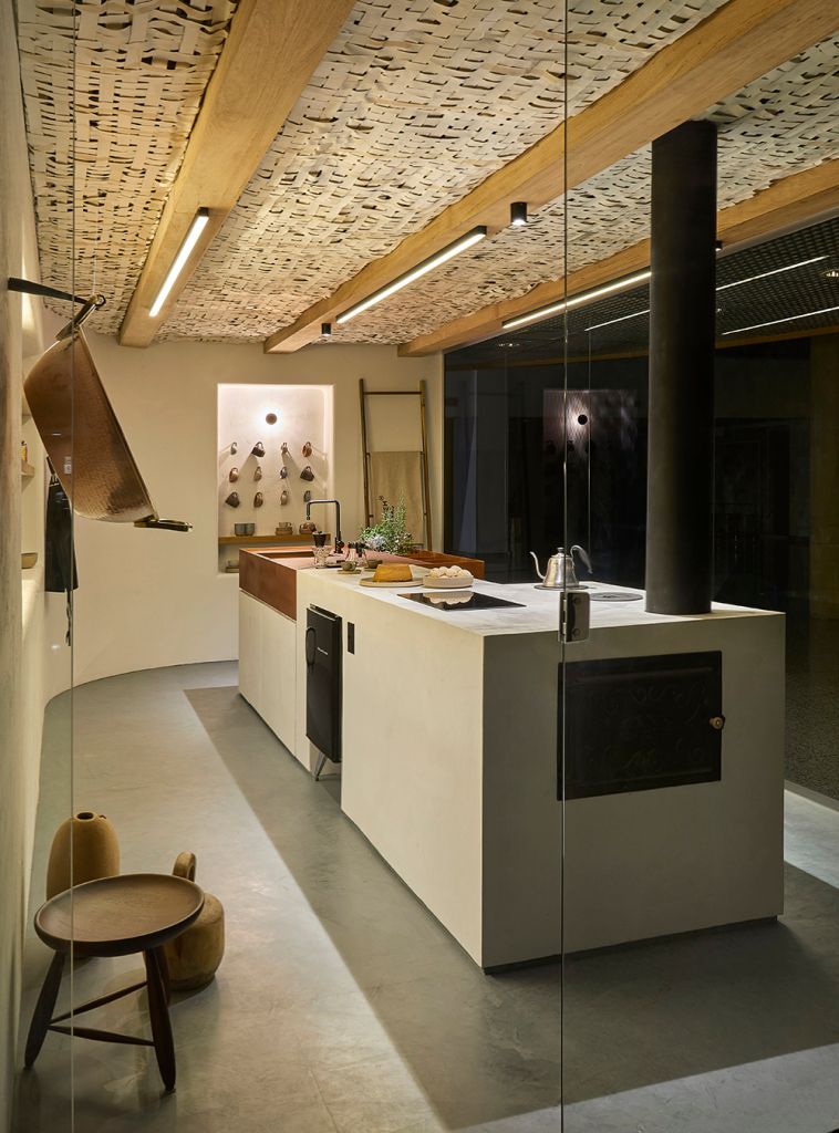 Vista externa da cozinha, com bancada e arranjo de canecas ao fundo