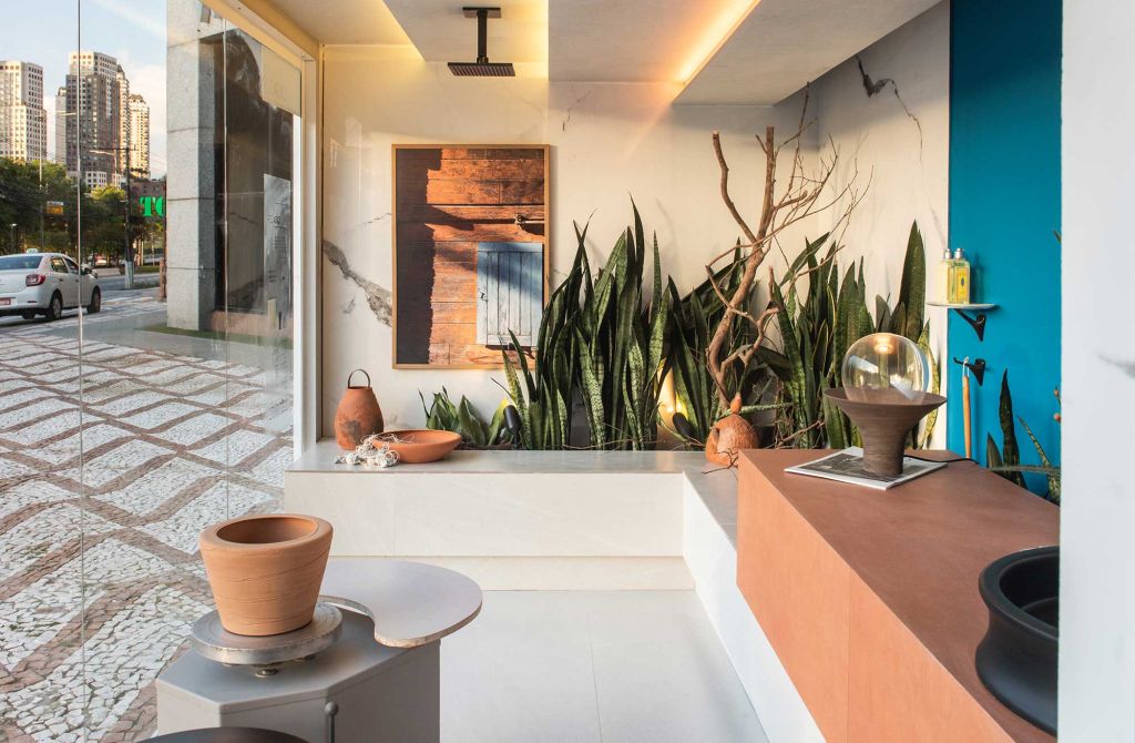 Marcelo Diniz e Mateus Finzetto criaram um jardim dentro do seu Banheiro do Ceramista: a espada-de-São-Jorge aparece junto com galhos secos e uma casinha de João-de-barro.