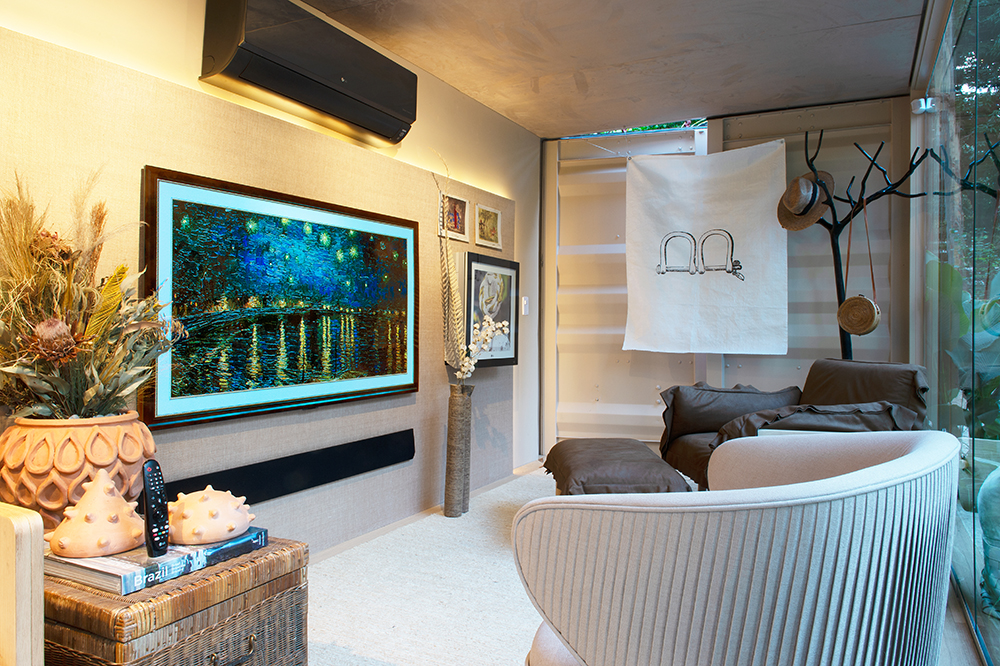 Sala de tv com duas poltronas. Na tv, imagem de pintura de Van Gogh