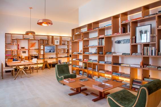 casacor-rio-lia-siqueira Biblioteca com duas poltronas verdes e estantes vazadas de madeira