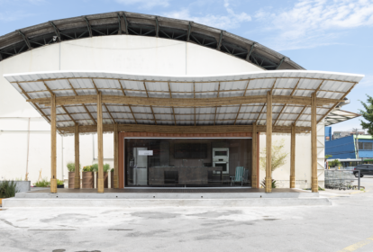 Contêiner da cozinha comunitária de frente, com deck, em primeiro plano; da esquerda para a direita: geladeira, bancada e torre de eletros ao fundo.
