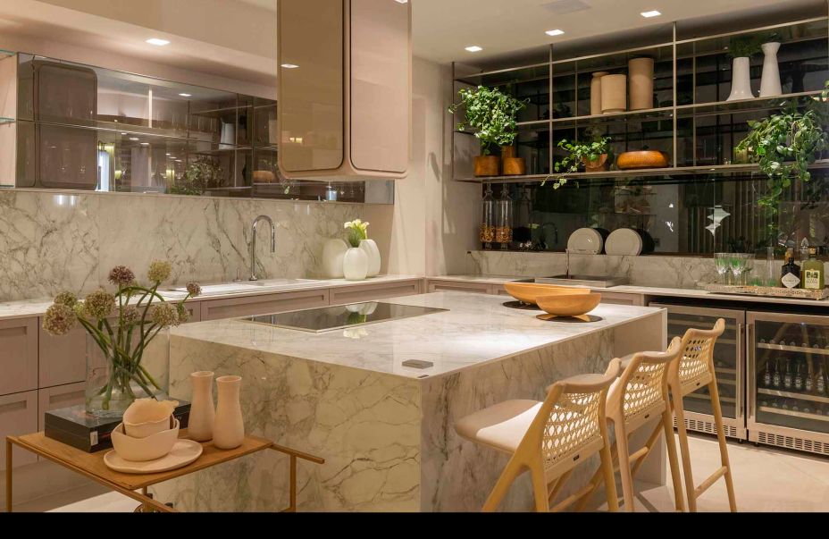Espaço Deca de uma cozinha com ilha de mármore com duas cadeiras a frente para receber convidados