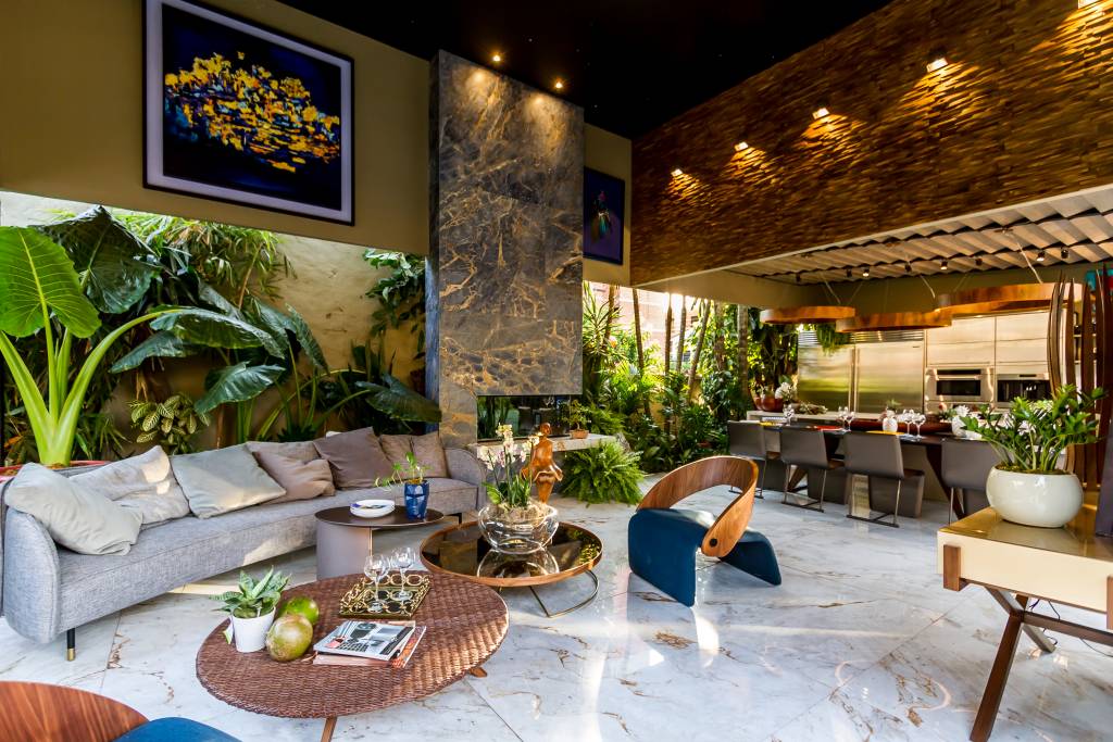 piso de marmore em uma sala de estar com plantas e sofás distribuídos no ambiente