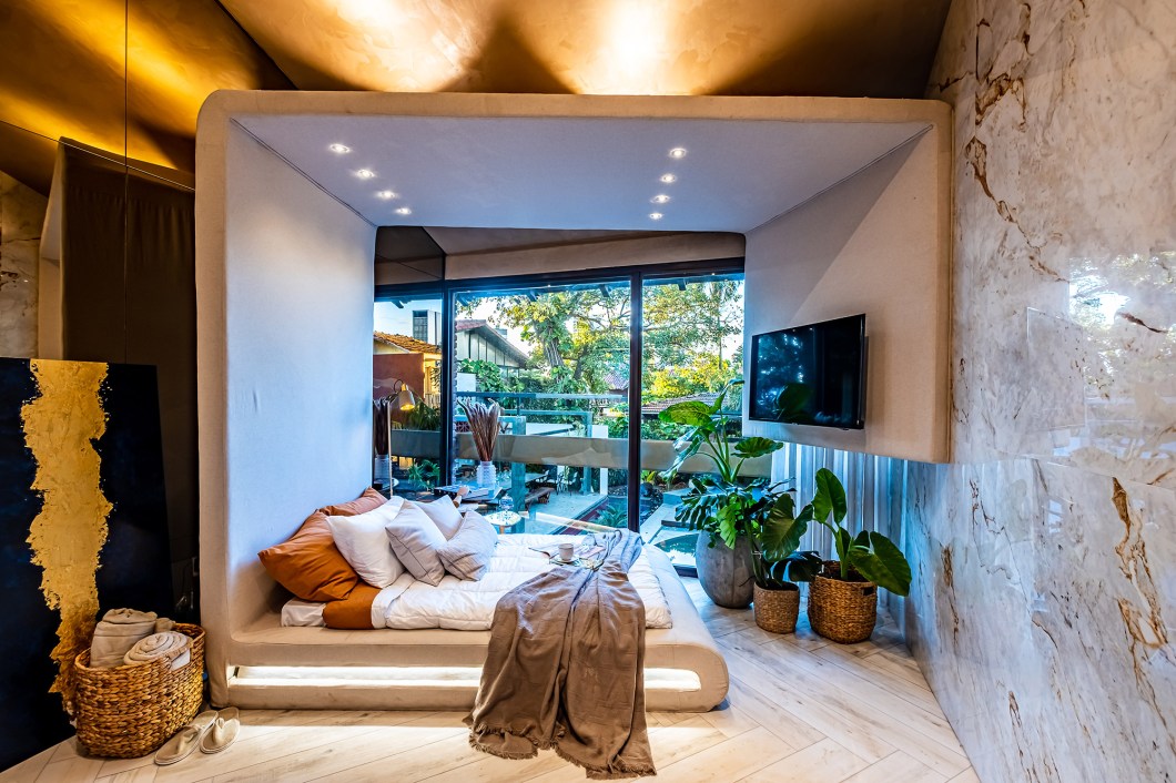 Dormitorio Reconexión - Kelly Leite. “Com a pandemia, a casa se tornou totalmente o nosso refúgio, um espaço que gera proteção e reconexão”, explica a profissional. É por isso que ela propõe um quarto contemporâneo que se conecta aos sentidos por meio de materiais como o mármore, o linho e a madeira. A cama é envolta numa estrutura que oferece descanso e tecnologia e o projeto nos convida a realizar diferentes atividades: trabalhar, ler, assistir televisão ou simplesmente admirar a vista. Dormitorio Reconexión - Kelly Leite. “Com a pandemia, a casa se tornou totalmente o nosso refúgio, um espaço que gera proteção e reconexão”, explica a profissional. É por isso que ela propõe um quarto contemporâneo que se conecta aos sentidos por meio de materiais como o mármore, o linho e a madeira. A cama é envolta numa estrutura que oferece descanso e tecnologia e o projeto nos convida a realizar diferentes atividades: trabalhar, ler, assistir televisão ou simplesmente admirar a vista.