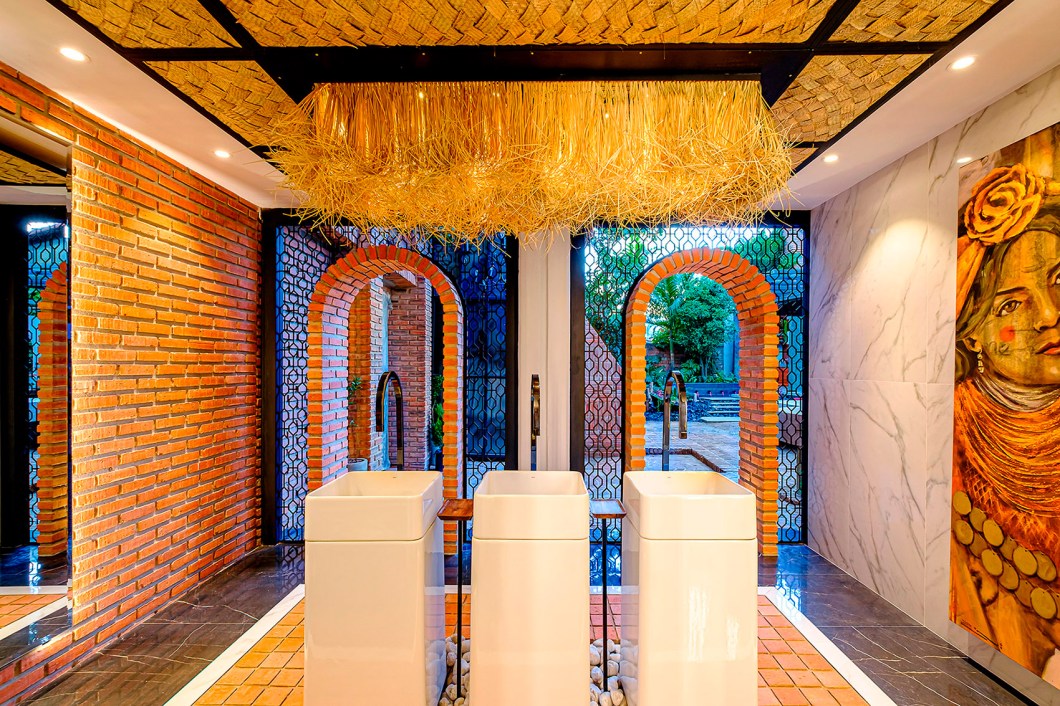 Baño Orígenes - Brenda Quezada e Diego Iriarte. Cada canto dos 43 m² do espaço tem um propósito: a entrada principal é marcada pelo imponente arco de tijolos rodeado por placas de metal. Na parte interna, toques indígenas da região compõem com revestimentos em tons de preto e branco e detalhes em madeira. O teto possui tecidos trançados, que também são aplicados nas portas de entrada dos cubículos dos banheiros. Baño Orígenes - Brenda Quezada e Diego Iriarte. Cada canto dos 43 m² do espaço tem um propósito: a entrada principal é marcada pelo imponente arco de tijolos rodeado por placas de metal. Na parte interna, toques indígenas da região compõem com revestimentos em tons de preto e branco e detalhes em madeira. O teto possui tecidos trançados, que também são aplicados nas portas de entrada dos cubículos dos banheiros.
