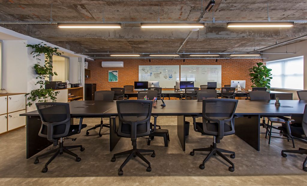 Grandes bancadas e cadeiras executivas no escritório da Korman Arquitetos