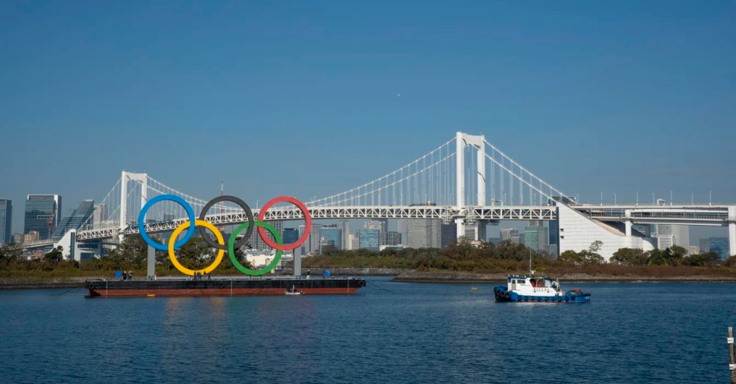 Com 15,3 m de altura e 32,6 m de comprimento, os Arcos Olímpicos ficam no Odaiba Marine Park. Muitos estúdios de TV se localizam nos arredores, o que faz com que a paisagem se torne pano de fundo de diversas transmissões. Com 15,3 m de altura e 32,6 m de comprimento, os Arcos Olímpicos ficam no Odaiba Marine Park. Muitos estúdios de TV se localizam nos arredores, o que faz com que a paisagem se torne pano de fundo de diversas transmissões.