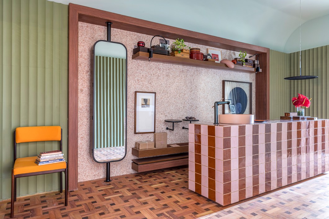 Kika Tiengo - Hall Abluo. Em sua estreia na CASACOR, a arquiteta apresenta um ambiente (de 17 m²) que ganhou relevância com a pandemia. O nome Abluo diz tudo: significa limpeza, purificação. “É no hall que lavamos as mãos, tiramos os sapatos, deixamos o mundo para trás e entramos no ninho”, diz Kika Tiengo. O lavatório em cerâmica artesanal é destaque. Cores e texturas lembram o otimismo do Memphis, movimento que marcou o design pós-moderno. Entre as escolhas sustentáveis estão o papel de parede líquido reutilizável e o piso de demolição. Kika Tiengo - Hall Abluo. Em sua estreia na CASACOR, a arquiteta apresenta um ambiente (de 17 m²) que ganhou relevância com a pandemia. O nome Abluo diz tudo: significa limpeza, purificação. “É no hall que lavamos as mãos, tiramos os sapatos, deixamos o mundo para trás e entramos no ninho”, diz Kika Tiengo. O lavatório em cerâmica artesanal é destaque. Cores e texturas lembram o otimismo do Memphis, movimento que marcou o design pós-moderno. Entre as escolhas sustentáveis estão o papel de parede líquido reutilizável e o piso de demolição.