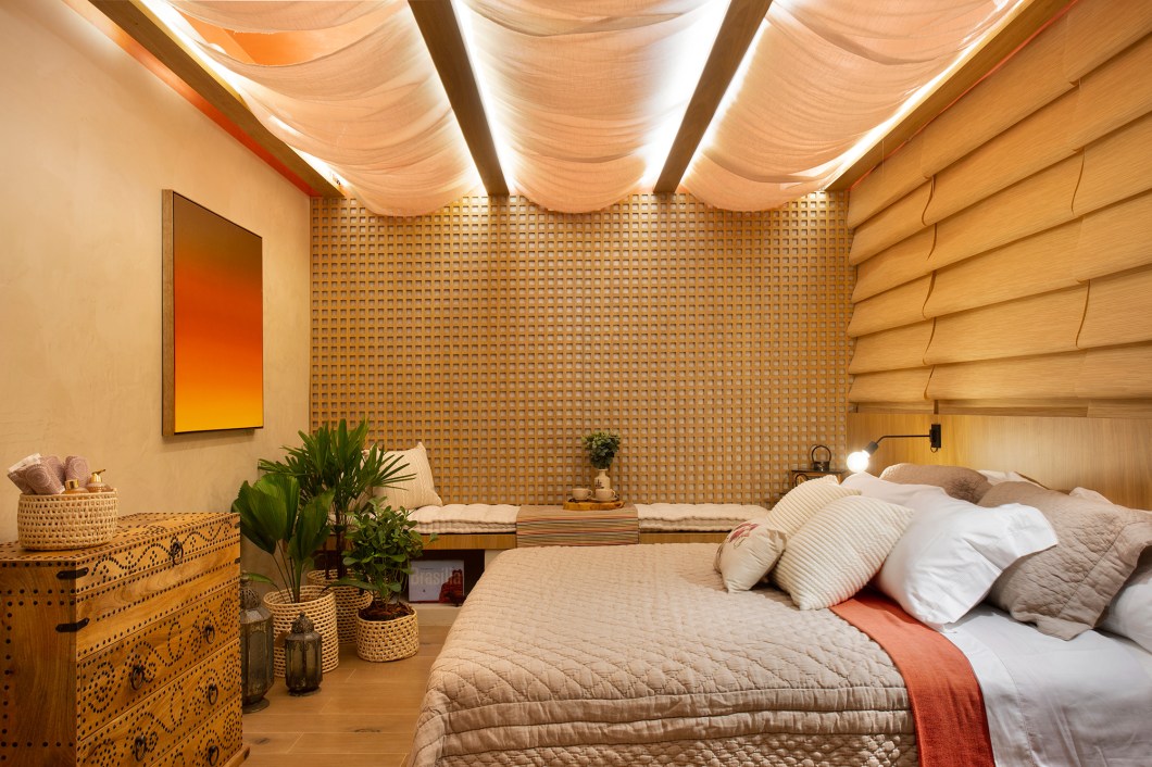Clarissa Camanho - Refúgio Aconchego. Neste lugar para relaxar, as cores e texturas do deserto criam sensação de solitude. A referência aparece na cor de areia das paredes, com textura velvet, e no teto terracota avermelhado, que remete ao pôr do sol. As dunas estão representadas no movimento dos tecidos no teto e paredes, contrastando com a rusticidade do banco de leitura em alvenaria com nichos para livros. O Refúgio Aconchego foi pensado para ser um canto de descanso da vida acelerada, trazendo elementos que convidam a entrar, relaxar e se distanciar do mundo exterior. Clarissa Camanho - Refúgio Aconchego. Neste lugar para relaxar, as cores e texturas do deserto criam sensação de solitude. A referência aparece na cor de areia das paredes, com textura velvet, e no teto terracota avermelhado, que remete ao pôr do sol. As dunas estão representadas no movimento dos tecidos no teto e paredes, contrastando com a rusticidade do banco de leitura em alvenaria com nichos para livros. O Refúgio Aconchego foi pensado para ser um canto de descanso da vida acelerada, trazendo elementos que convidam a entrar, relaxar e se distanciar do mundo exterior.