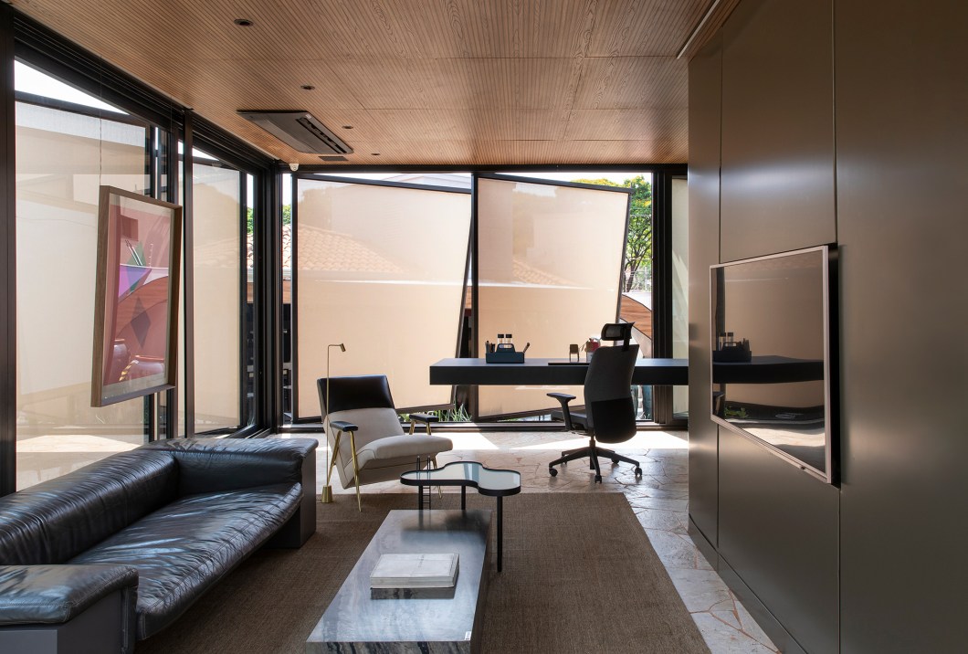 EFC Arquitetura - Espaço Soleil Home Office. O desenho final do espaço teve como ponto de partida o desejo de propor algo que amenizasse o clima quente de Ribeirão Preto. O brise-soleil foi utilizado como elemento principal na arquitetura. Automatizado, ele se movimenta de acordo com o sol, trazendo conforto térmico sem perder a iluminação natural. Para integrar living, escritório, café, área de pesquisa e lavabo, o arquiteto Eduardo Franco Correia optou por uma mescla de móveis e objetos de arte de várias épocas da história do design. EFC Arquitetura - Espaço Soleil Home Office. O desenho final do espaço teve como ponto de partida o desejo de propor algo que amenizasse o clima quente de Ribeirão Preto. O brise-soleil foi utilizado como elemento principal na arquitetura. Automatizado, ele se movimenta de acordo com o sol, trazendo conforto térmico sem perder a iluminação natural. Para integrar living, escritório, café, área de pesquisa e lavabo, o arquiteto Eduardo Franco Correia optou por uma mescla de móveis e objetos de arte de várias épocas da história do design.