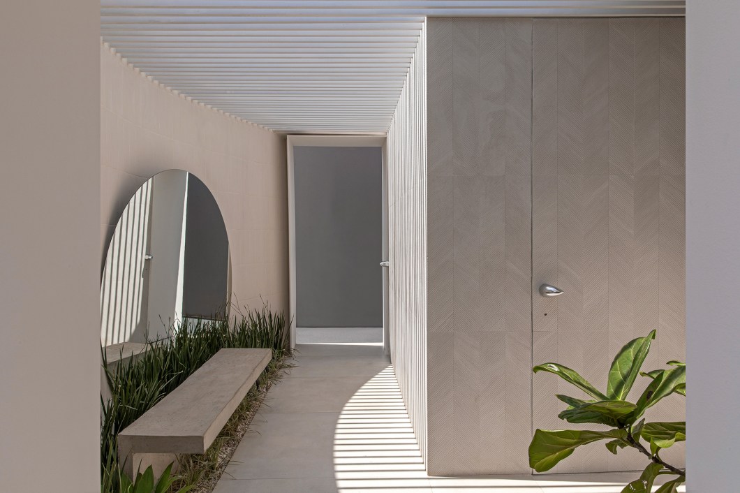 QOZ Arquitetos - Banheiro Eido. O termo Eido é utilizado nas aldeias portuguesas para retratar um recinto descoberto, de proporções pequenas, anexo à casa matriz. Para o escritório, essa simbologia remete a uma volta no tempo: a inovação aparece com a união de dois volumes, um curvo e outro retangular. Entre eles, a pérgola dá origem ao jogo luz e sombra – elemento que favorece a integração com a área externa. A arquitetura limpa é marcada também pela equilibrada composição de tons e texturas, que proporciona uma linguagem única ao espaço. QOZ Arquitetos - Banheiro Eido. O termo Eido é utilizado nas aldeias portuguesas para retratar um recinto descoberto, de proporções pequenas, anexo à casa matriz. Para o escritório, essa simbologia remete a uma volta no tempo: a inovação aparece com a união de dois volumes, um curvo e outro retangular. Entre eles, a pérgola dá origem ao jogo luz e sombra – elemento que favorece a integração com a área externa. A arquitetura limpa é marcada também pela equilibrada composição de tons e texturas, que proporciona uma linguagem única ao espaço.