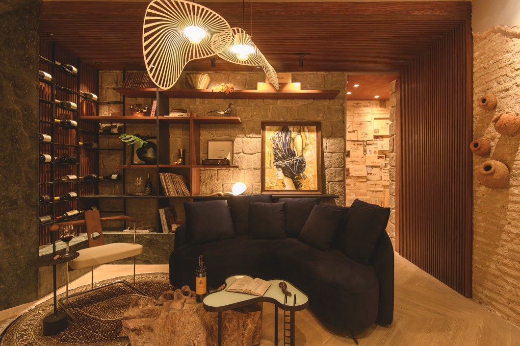 Studio Linear - Lara Correia e Nahalia Rangel - Sala do Vinho. A arquitetura moderna, tão característica nos projetos da dupla, foi adaptada ao ambiente que carrega histórias e elementos da década de 1970, como o revestimento de pedra e os brises. No projeto, a valorização da madeira, de tons mais sóbrios e de iluminação indireta, resulta em um espaço aconchegante e sofisticado. A ideia é proporcionar aos visitantes uma identificação imediata e despertar o desejo de vivenciar cada dia em uma sala de vinho ideal para uma experiência social e acolhedora. Studio Linear - Lara Correia e Nahalia Rangel - Sala do Vinho. A arquitetura moderna, tão característica nos projetos da dupla, foi adaptada ao ambiente que carrega histórias e elementos da década de 1970, como o revestimento de pedra e os brises. No projeto, a valorização da madeira, de tons mais sóbrios e de iluminação indireta, resulta em um espaço aconchegante e sofisticado. A ideia é proporcionar aos visitantes uma identificação imediata e despertar o desejo de vivenciar cada dia em uma sala de vinho ideal para uma experiência social e acolhedora.