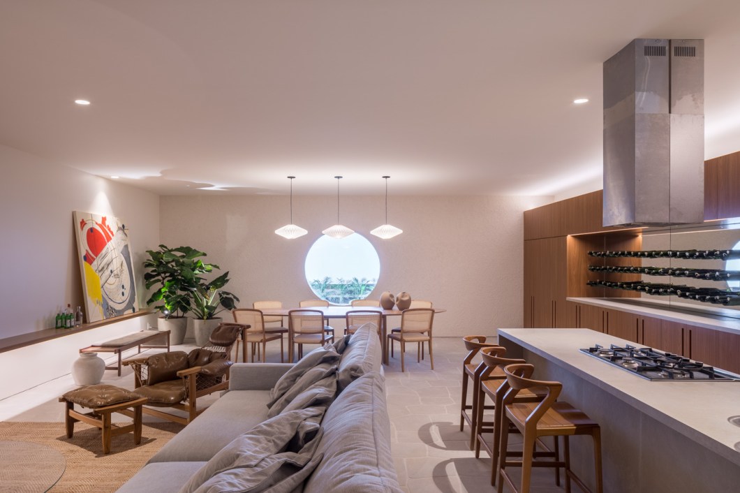 Maria Araújo - Espaço Gourmet. Um espaço amplo para receber é essencial hoje numa casa e inspirou a estreante na mostra, Maria Araújo, a criar o espaço de 90 m². Formas orgânicas e naturais e padrões mais monocromáticos compõem o ambiente. Há uso de madeira e muita vegetação. Destacam-se o porcelanato orgânico e os tecidos e os tapetes em fibras naturais. No mobiliário, chama a atenção a icônica poltrona jangada de Jean Gillon e a adega suspensa em alça de couro. O ambiente tem obra do artista Sando Gos. Maria Araújo - Espaço Gourmet. Um espaço amplo para receber é essencial hoje numa casa e inspirou a estreante na mostra, Maria Araújo, a criar o espaço de 90 m². Formas orgânicas e naturais e padrões mais monocromáticos compõem o ambiente. Há uso de madeira e muita vegetação. Destacam-se o porcelanato orgânico e os tecidos e os tapetes em fibras naturais. No mobiliário, chama a atenção a icônica poltrona jangada de Jean Gillon e a adega suspensa em alça de couro. O ambiente tem obra do artista Sando Gos.