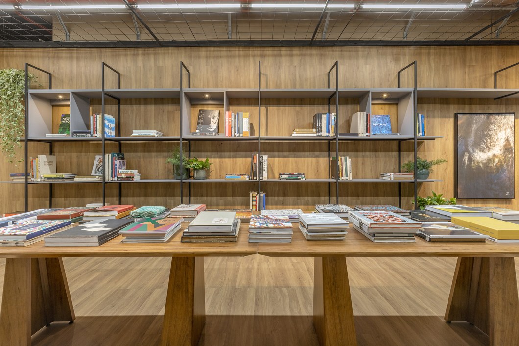 Glaucia Almeida - Livraria. Com o objetivo de fugir da estética de livrarias comuns, a designer de interiores utilizou a biofilia para compor o espaço, numa união com o estilo industrial - que aparece na serralheria do forro, nas prateleiras e na porta. A natureza marca presença nas plantas e nas cores das paredes, que foram revestidas de piso vinílico Peças de cerâmica italiana do acervo da livraria dão charme ao ambiente, assim como fotografias de Boechat. Com 68 m², o projeto foi pensado para ser funcional e, ao mesmo tempo, acolhedor, com a natureza presente para dar uma sensação de calmaria e respiro para a mente. Glaucia Almeida - Livraria. Com o objetivo de fugir da estética de livrarias comuns, a designer de interiores utilizou a biofilia para compor o espaço, numa união com o estilo industrial - que aparece na serralheria do forro, nas prateleiras e na porta. A natureza marca presença nas plantas e nas cores das paredes, que foram revestidas de piso vinílico Peças de cerâmica italiana do acervo da livraria dão charme ao ambiente, assim como fotografias de Boechat. Com 68 m², o projeto foi pensado para ser funcional e, ao mesmo tempo, acolhedor, com a natureza presente para dar uma sensação de calmaria e respiro para a mente.