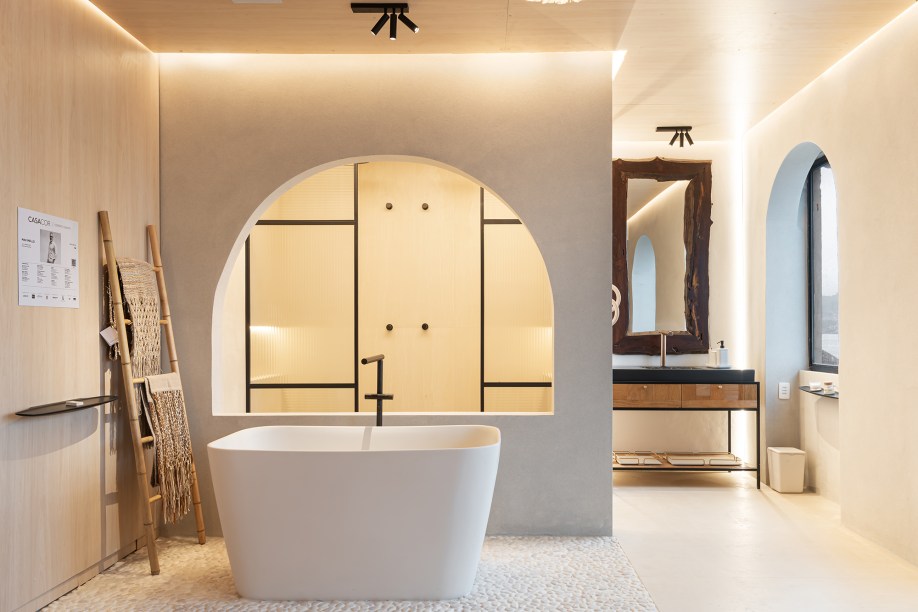 Max Mello - Spa Deca. Estando em perfeita sintonia com a CASACOR há 24 anos, o arquiteto assina um espaço que segue a linha de materiais rústicos e possui uma pegada clean, com destaques para o lustre da lightdesigner Cristiane Bertolucci de tecido de algodão natural, que traz uma sensação de leveza. No centro do espaço, junto à sala de banho, foi posicionada uma banheira de imersão, que transformou o ambiente em um oásis particular, oferecendo um convite ao conforto. Para finalizar, a decoração mescla trabalhos da artista contemporânea Nardelli e peças de artesanato tradicional de dois artesãos da prainha de Vila Velha, que remetem à tradição étnica local.