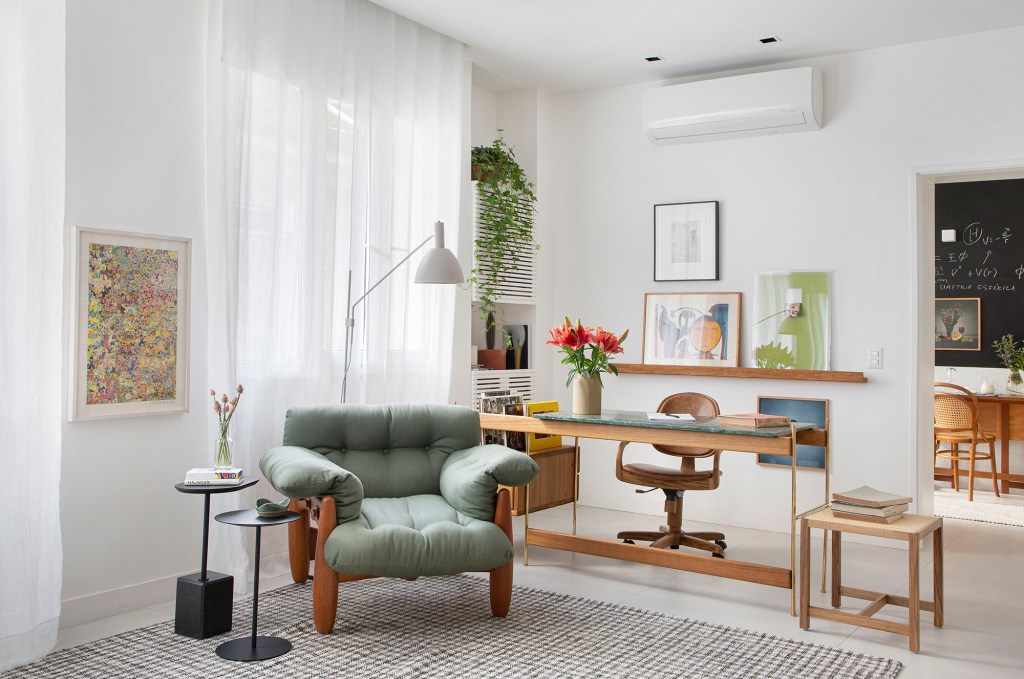 estante-com-mais-de-1500-livros-e-a-estrela-deste-ape-de-60-m² (7) apartamento rio de janeiro decoracao adriana esteves sala home office poltrona tapete