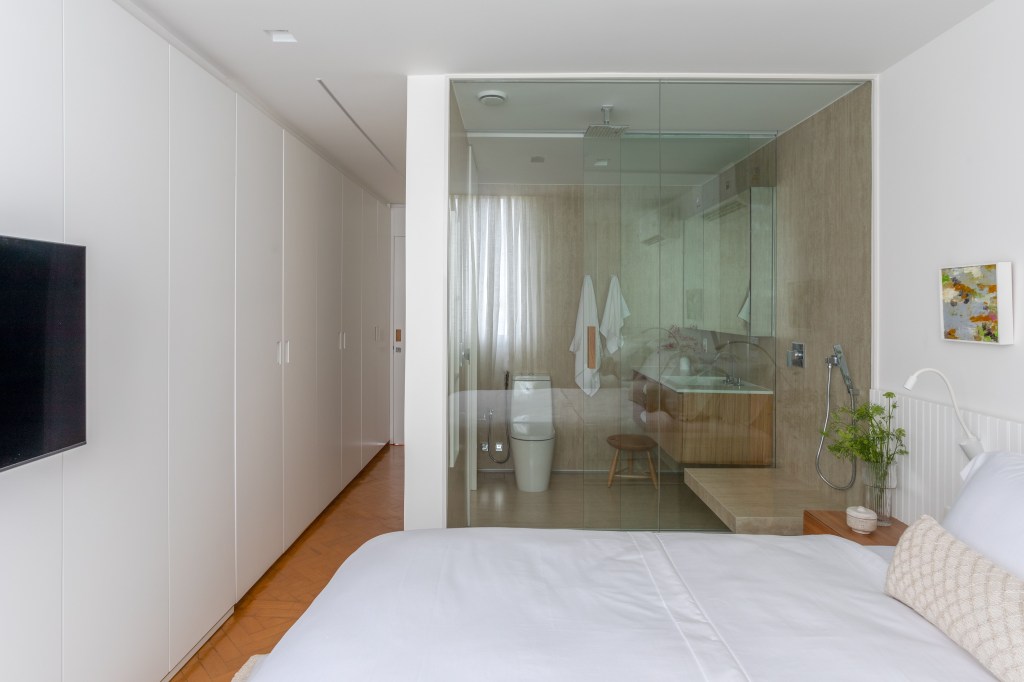 apartamento-de-95-m²-fica-pronto-em-tres-meses-para-receber-o-bebe-da-familia (10) quarto banheiro cama vidro apartamento diego raposo rio de janeiro
