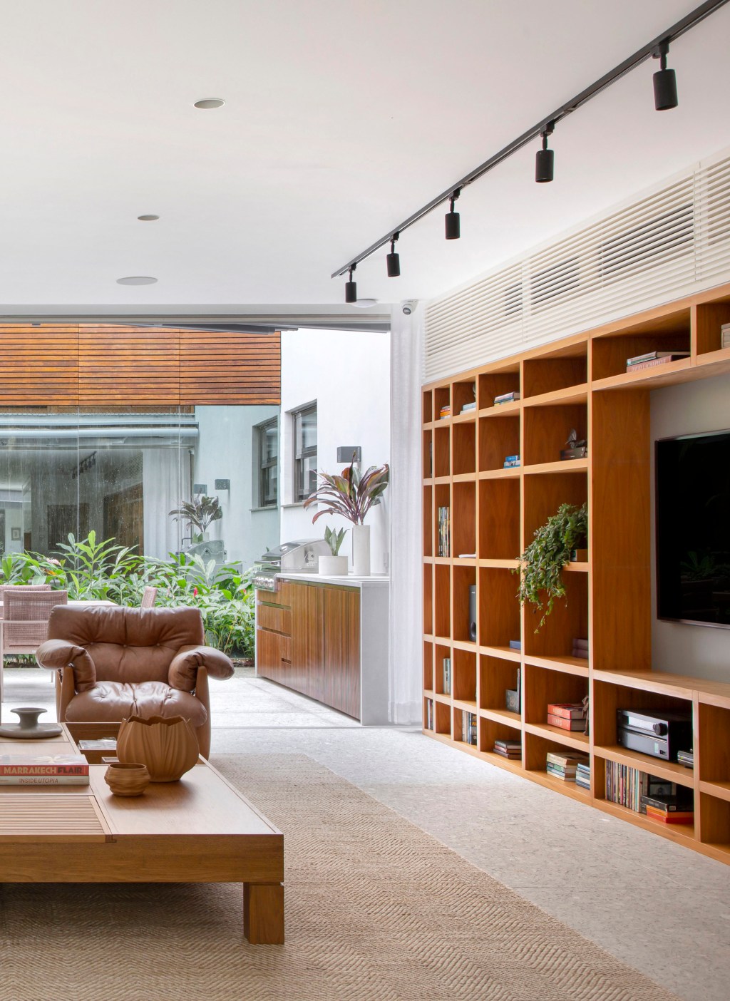 casa-no-leblon-possui-escorregador-na-escada-e-muitas-obras-de-arte (17) casa natalia lemos reforma arquitetura decoração rio de janeiro sala estar tv estante madeira