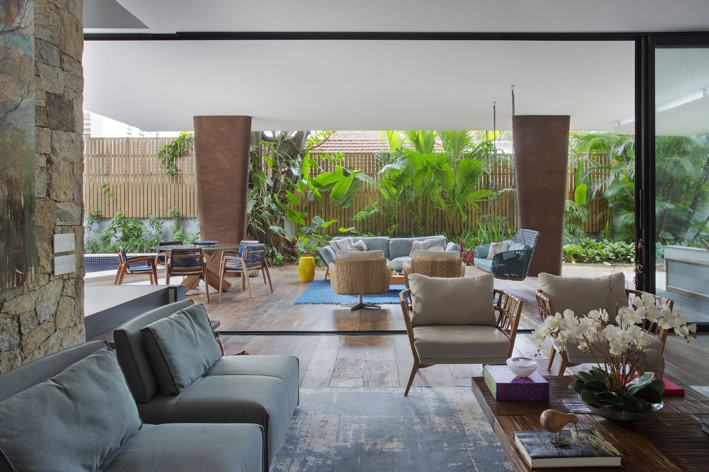 reforma-integra-esta-casa-de-790-m²-a-natureza-do-rio-de-janeiro (17) reforma casa rio de janeiro ketlein amorin sala estar sofa tapete quadro varanda poltrona