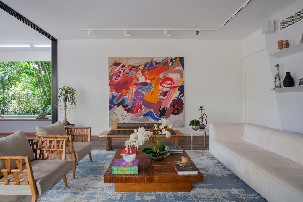 reforma-integra-esta-casa-de-790-m²-a-natureza-do-rio-de-janeiro (18) reforma casa rio de janeiro ketlein amorin sala estar sofa tapete quadro estante arte