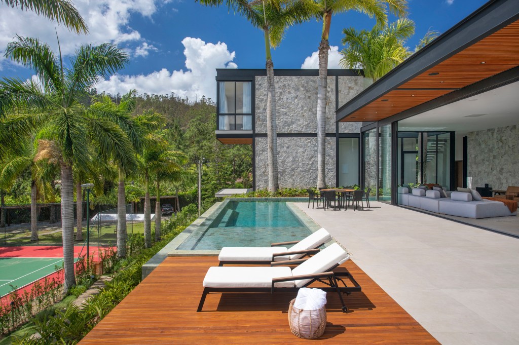 casa-de-campo-em-topo-da-montanha-fica-em-meio-a-palmeiras-imperiais-gigantes-denilson-machado (2) Casa de campo palmeiras imperiais gigantes Beta Arquitetura Rio de Janeiro Bernardo Gaudie-Ley Tânia Braida casacor arquitetura area externa varanda piscina deque jardim paisagismo fachada