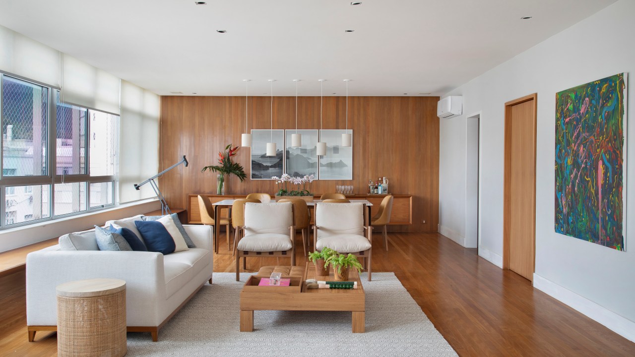 Apartamento alugado 240 m2 nova área social três semanas Brise Arquitetura sala de jantar parede de madeira mesa cadeira quadro sala estar sofa