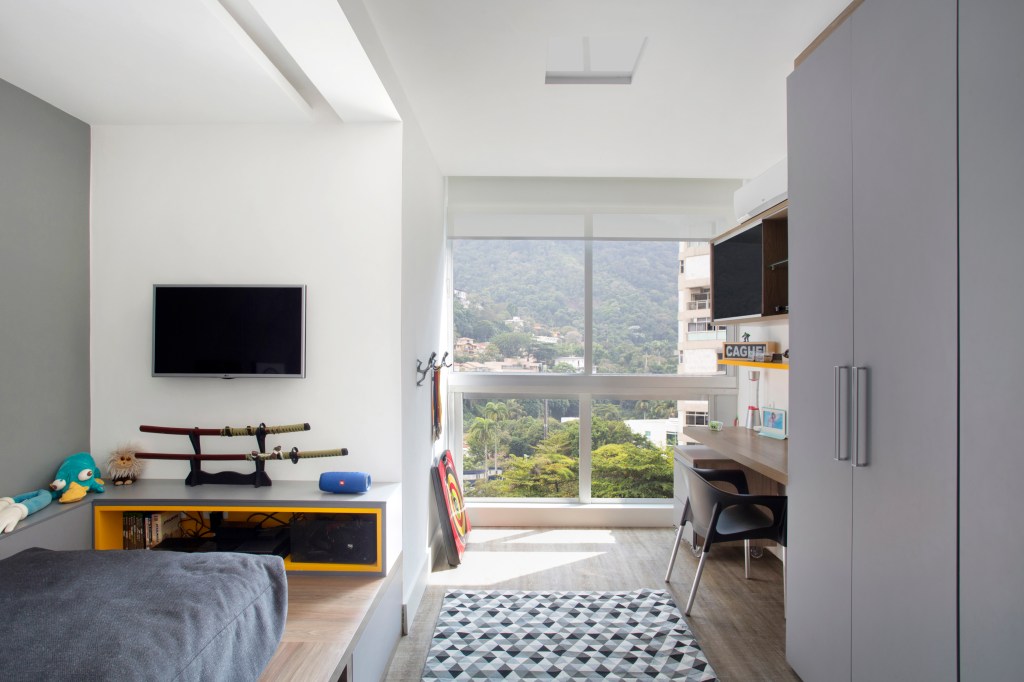 integracao-vigas-aparentes-ape-vista-mar-ketlein-amorin-mca-estudio-quarto-filho integracao ape apartamento vigas aparentes vista mar ketlein amorin rio de janeiro quarto adolescente tv mesa cama futon