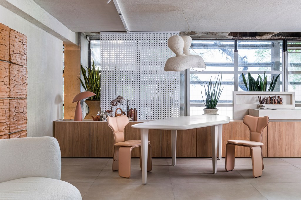 Gustavo Martins Arquitetos – Odoiá Gustavo Martins Arquitetos - Odoiá. Projeto da CASACOR São Paulo 2023. Na foto, sala de jantar com mesa geométrica, quadro de lama e aparador.