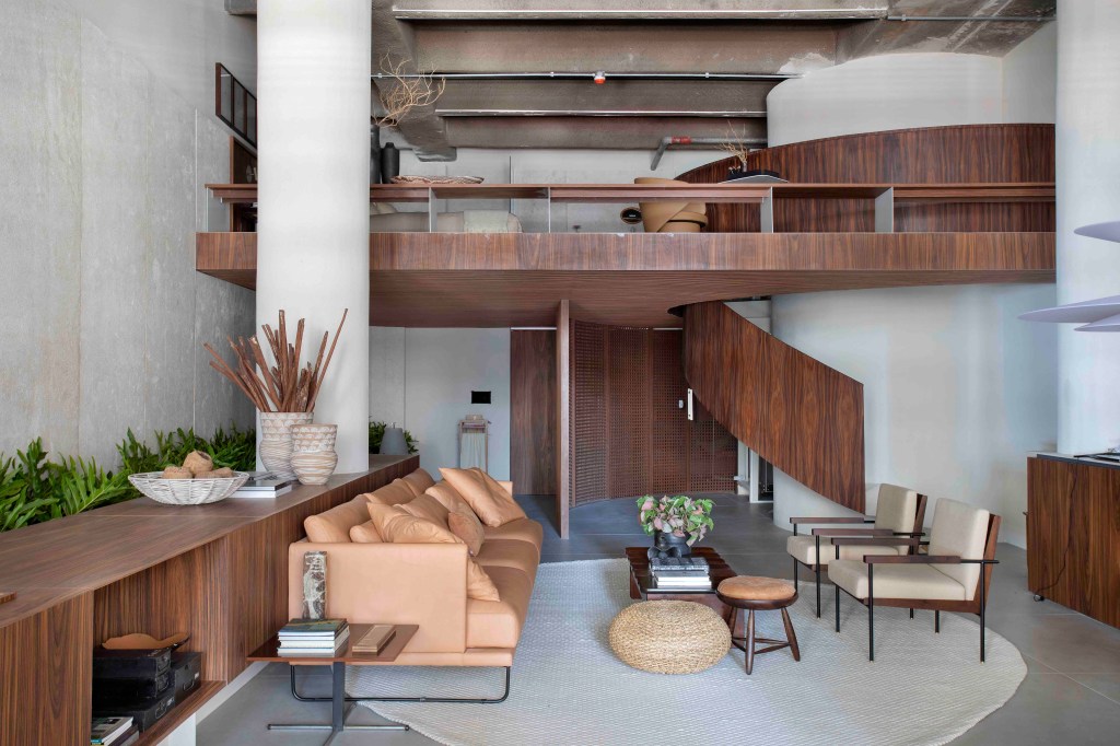 Ticiane Lima - Loft (In)terno. Projeto da CASACOR São Paulo 2023. Na foto, loft com superfícies de madeira, sala de estar, quarto e escada.