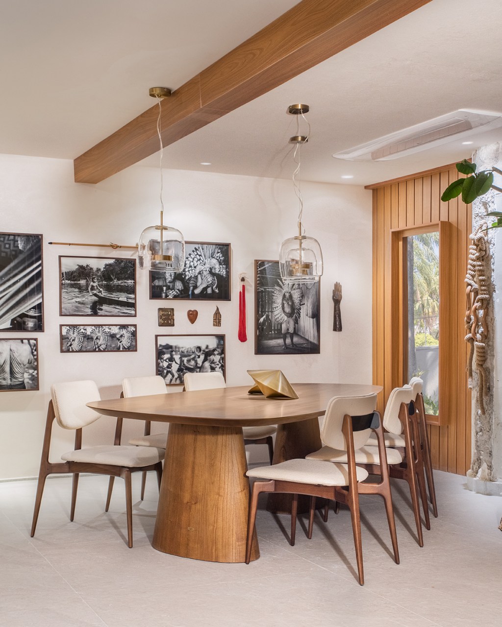 Bruno Moraes - Cozinha Funcional. Projeto da CASACOR São Paulo 2023. Na foto, sala de jantar com mesa de madeira e quadros.