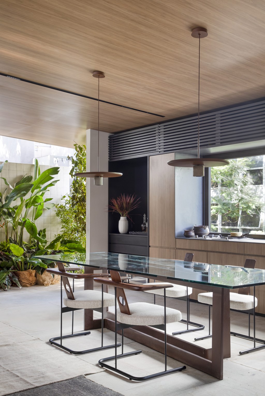navarro-arquitetura-casa-araxa-casacor-sao-paulo-2023-credito-mca-estudio (16) Navarro Arquitetura - Casa Araxá. Projeto da CASACOR São Paulo 2023. Na foto sala de jantar com mesa de vidro e cozinha.