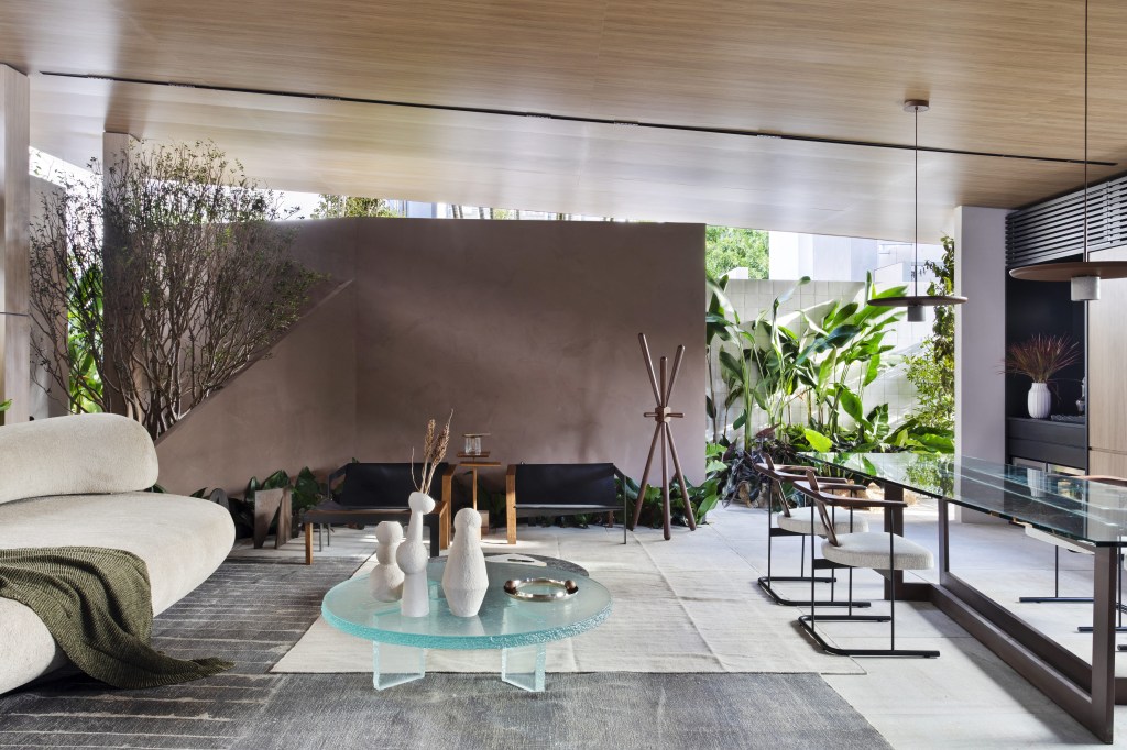 navarro-arquitetura-casa-araxa-casacor-sao-paulo-2023-credito-mca-estudio (23) Navarro Arquitetura - Casa Araxá. Projeto da CASACOR São Paulo 2023. Na foto, sala de estar e jantar com sofá curvo, tapete e mesa.