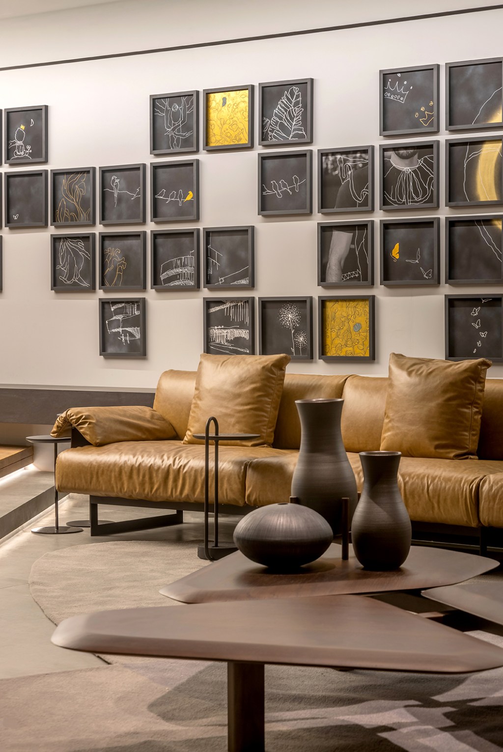 William Hanna - Casa Cosentino. Projeto da CASACOR Goiás 2023. Na foto, sala com sofá de couro e quadros na parede.
