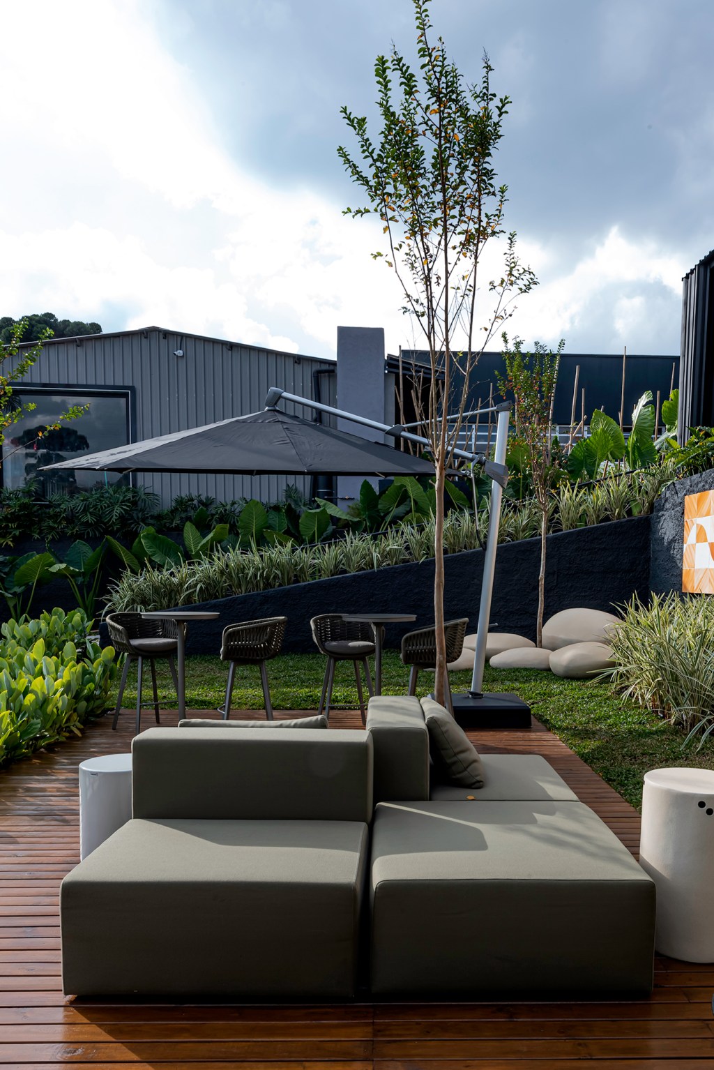 july-franchesca-dallagrana-the-landscape-casacor-parana-2023-credito-duas-fotografia July Franchesca Dallagrana - The Landscape. Projeto da CASACOR Paraná 2023. Na foto, jardim com sofa ilha, ombrelone e cadeiras.