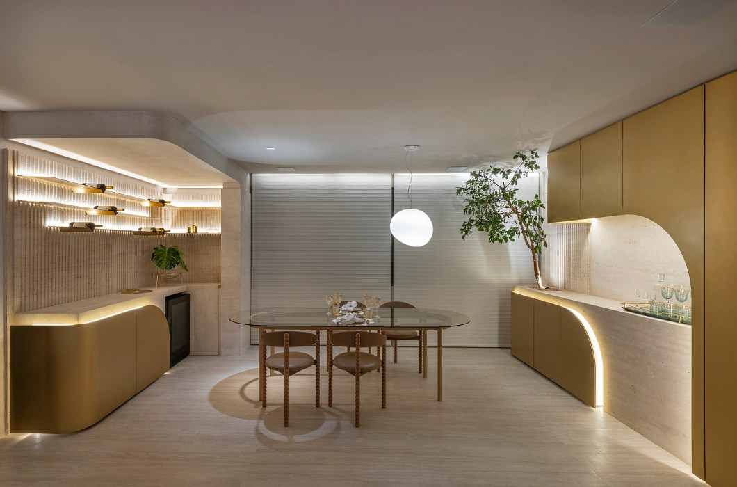 Renata Machado e André Magalhães Arquitetura e Design - Sala e lavabo do apartamento. A ideia de refúgio urbano em contraposição ao frenesi do dia a dia está traduzida principalmente na presença marcante das formas orgânicas e na escolha de uma paleta de cores suaves que transmite fluidez e serenidade. Um ambiente interativo que utiliza a tecnologia a favor da praticidade. Parte do revestimento é em travertino, trabalhado tanto na pedra lisa como ranhurada, presente no lavabo, com mesmo conceito orgânico, na adega e no bar. Renata Machado e André Magalhães Arquitetura e Design - Sala e lavabo do apartamento. A ideia de refúgio urbano em contraposição ao frenesi do dia a dia está traduzida principalmente na presença marcante das formas orgânicas e na escolha de uma paleta de cores suaves que transmite fluidez e serenidade. Um ambiente interativo que utiliza a tecnologia a favor da praticidade. Parte do revestimento é em travertino, trabalhado tanto na pedra lisa como ranhurada, presente no lavabo, com mesmo conceito orgânico, na adega e no bar.