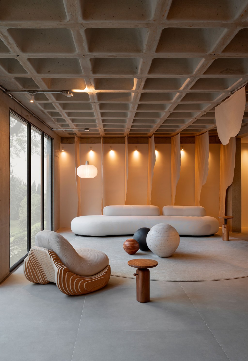 life-projects-lobby-essencia-casacor-minas-gerais-2023-credito-ny18 (4) Life projects (José Lourenço e Marina Figueiredo) - Lobby Essência. Projeto da CASACOR Minas Gerais 2023. Na foto, sala com sofá curvo, parede de madeira e poltrona.