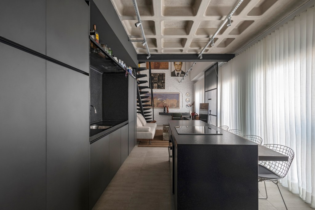 loft-64-m2-decor-industrial-colecao-arte-moradores-junior-piacesi-credito-estudio-ny18 (14) Loft de 64 m² ganha décor industrial e coleção de arte dos moradores. Projeto de Junior Piacesi. Na foto, cozinha com ilha e marcenaria preta.