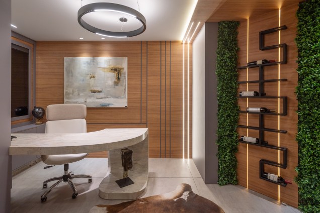 Juliani Zanelato - Gabinete Urbano. Nada melhor do que se sentir pertencente e acolhido pelo seu local de trabalho ou estudo. Por isso, em meio aos livros, tons terrosos criam uma atmosfera aconchegante no ambiente. Os 13 m² ainda abrigam o sistema de monitoramento da residência, e o uso de pedras naturais, reforçam a funcionalidade do espaço. Destaque para a mesa, criada exclusivamente pelo escritório de arquitetura para o ambiente. Juliani Zanelato - Gabinete Urbano. Nada melhor do que se sentir pertencente e acolhido pelo seu local de trabalho ou estudo. Por isso, em meio aos livros, tons terrosos criam uma atmosfera aconchegante no ambiente. Os 13 m² ainda abrigam o sistema de monitoramento da residência, e o uso de pedras naturais, reforçam a funcionalidade do espaço. Destaque para a mesa, criada exclusivamente pelo escritório de arquitetura para o ambiente.