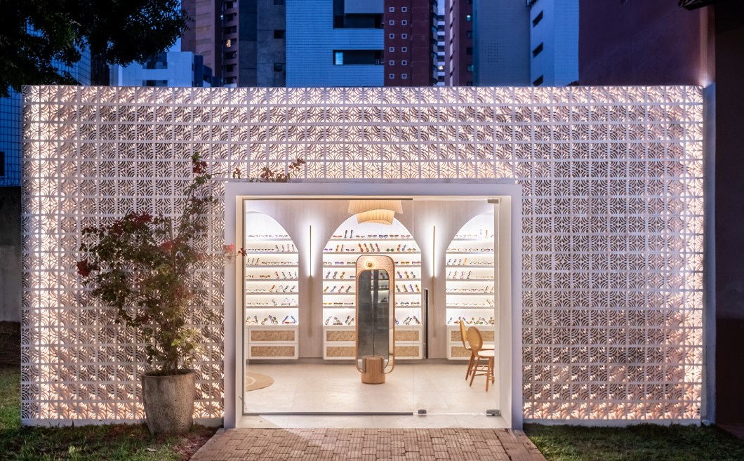 Christiane Boris - Luz do Sol (Loja de Óculos). <span>Inspirada pela serenidade da Riviera turca de Bodrum e Mykonos, Christiane projetou um espaço boutique de óculos, com um toque de casa de praia, que apresenta tons claros, brancos e de areia, permitindo que o sol realce os óculos multicoloridos da Gustavo Eyewear. O projeto inclui detalhes dourados e o uso criativo da palha de bambu no teto e nas gavetas. A fachada externa é uma homenagem ao modernismo brasileiro, incorporando cobogós de renda branca de bilro da Tavares Linha Decorativa. O resultado é uma fusão de elementos naturais e culturais, incorporando a alma do Ceará, o sol e a riqueza artesanal do estado.</span> Christiane Boris - Luz do Sol (Loja de Óculos). <span>Inspirada pela serenidade da Riviera turca de Bodrum e Mykonos, Christiane projetou um espaço boutique de óculos, com um toque de casa de praia, que apresenta tons claros, brancos e de areia, permitindo que o sol realce os óculos multicoloridos da Gustavo Eyewear. O projeto inclui detalhes dourados e o uso criativo da palha de bambu no teto e nas gavetas. A fachada externa é uma homenagem ao modernismo brasileiro, incorporando cobogós de renda branca de bilro da Tavares Linha Decorativa. O resultado é uma fusão de elementos naturais e culturais, incorporando a alma do Ceará, o sol e a riqueza artesanal do estado.</span>