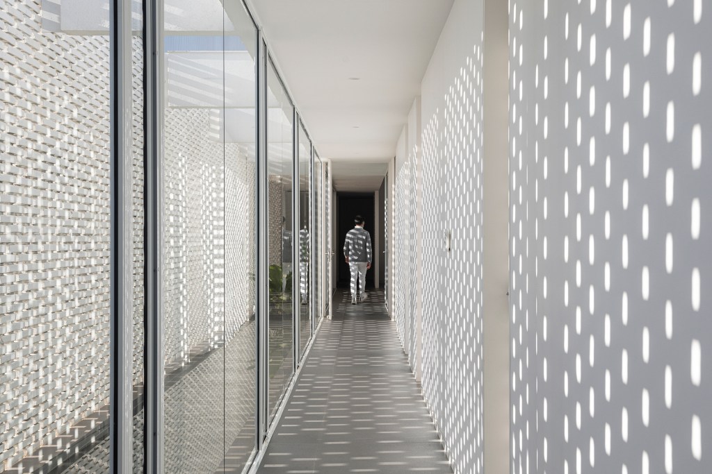 tijolos-brancos-vazados-compoem-fachada-casa-600-m2-brasilia-bloco-arquitetos-credito-joana-franca (4) Tijolos brancos e vazados compõem fachada de casa de 600 m² em Brasília. Projeto de Bloco Arquitetos. Na foto, corredor com muros de tijolo vazado.