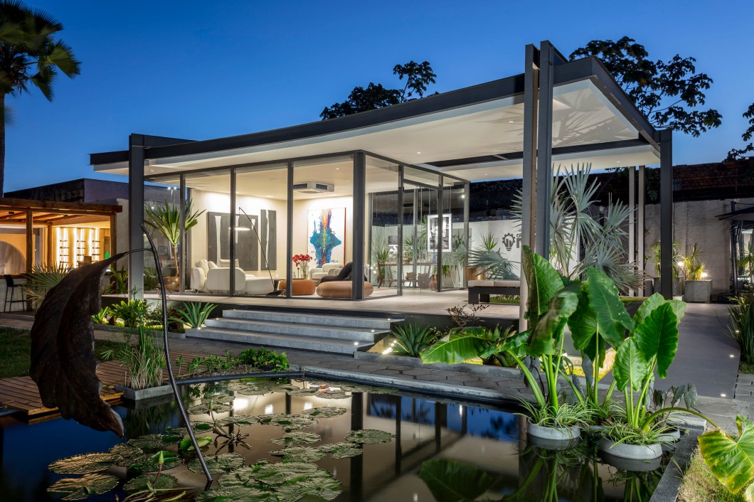 Carlos Rezende - Casa ROS. <span>A Casa ROS é uma construção em estrutura metálica onde o material e o método construtivo protagonizam absolutos como elementos arquitetônicos e não somente estruturais. O o arquiteto Carlos Rezende optou por explorar potencialidades típicas do aço, além de utilizar esquadrias com grandes planos envidraçados conectando o interior e o exterior nos limites e perspectivas, trazendo elementos do paisagismo e a visão das obras de arte de sua curadoria. A organicidade dos estofados cria unidade, integra e evidencia práticas de conversas sobre assuntos atuais, arte e seus campos de influência.</span> Carlos Rezende - Casa ROS. <span>A Casa ROS é uma construção em estrutura metálica onde o material e o método construtivo protagonizam absolutos como elementos arquitetônicos e não somente estruturais. O o arquiteto Carlos Rezende optou por explorar potencialidades típicas do aço, além de utilizar esquadrias com grandes planos envidraçados conectando o interior e o exterior nos limites e perspectivas, trazendo elementos do paisagismo e a visão das obras de arte de sua curadoria. A organicidade dos estofados cria unidade, integra e evidencia práticas de conversas sobre assuntos atuais, arte e seus campos de influência.</span>